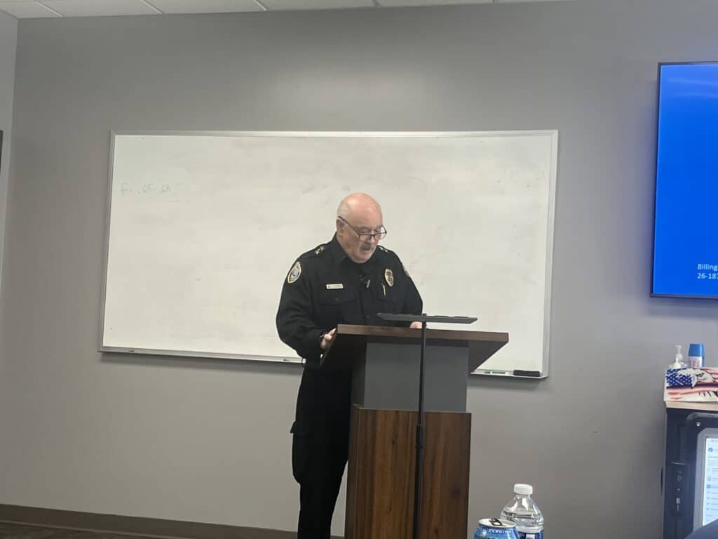 Chief Rich St. John speaking to an audience at a press conference.