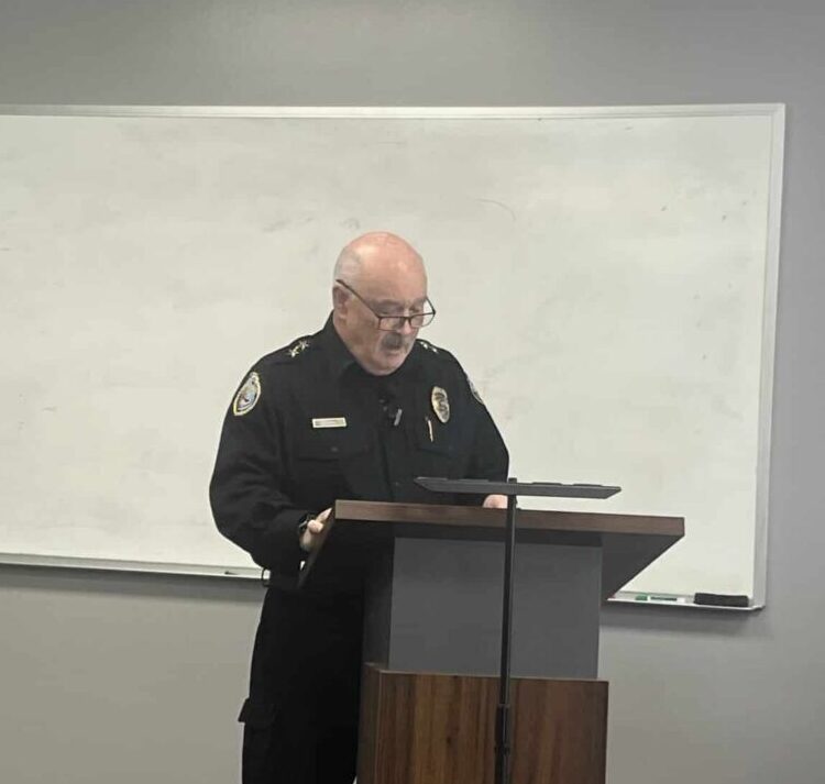 Chief Rich St. John speaking to an audience at a press conference.